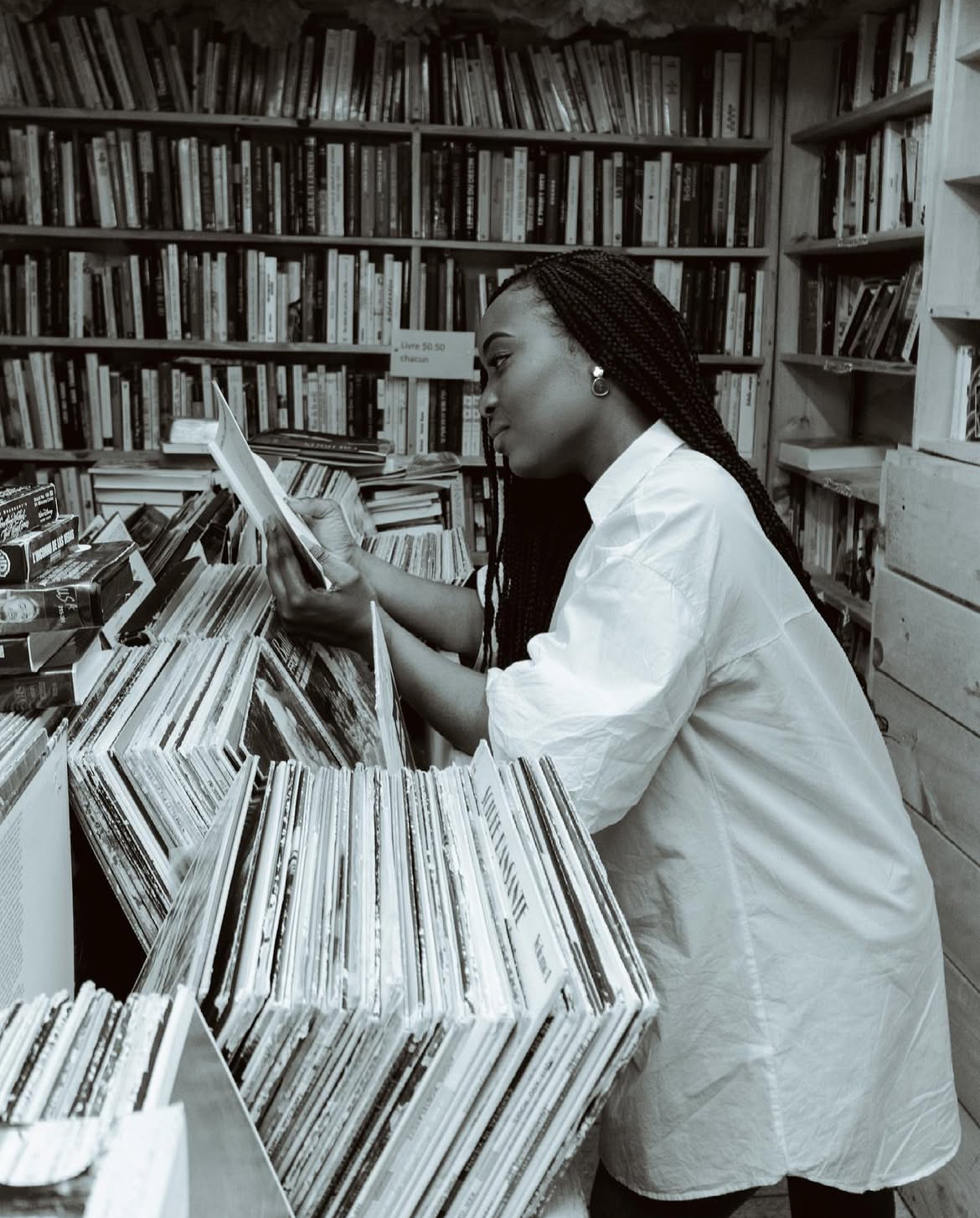 Photo de Christelle M. Kongolo, consultant un livre dans une bibliothèque.